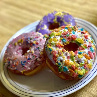 two sprinkled donuts on a plate