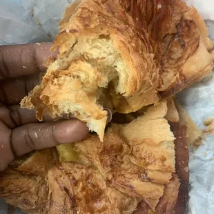 a hand holding a half eaten pastry
