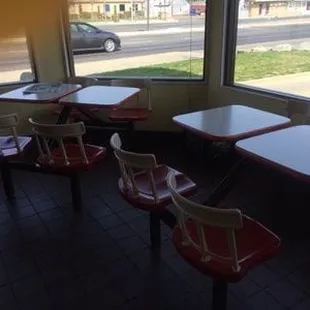 Cute little red and white booths with swiveling chairs and a panoramic view through the windows