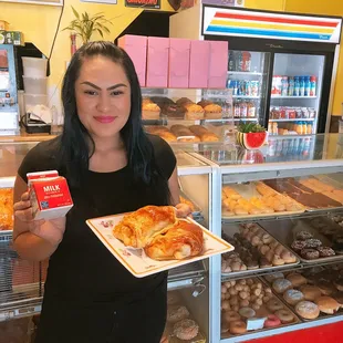 a woman holding a tray of donuts
