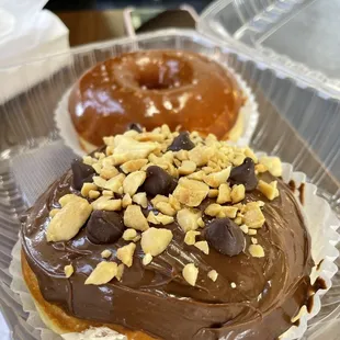a chocolate frosted donut with nuts on top