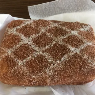 Apple and crème filled donut with brown and powdered sugar.  bomb dot com