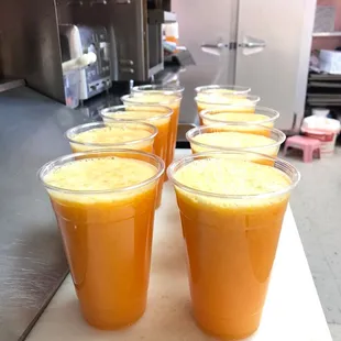 a row of cups of orange juice