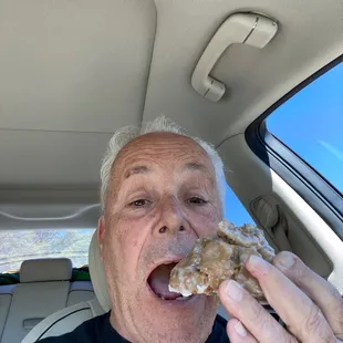 a man eating a donut in a car