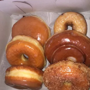 Raspberry jelly filled donut, regular glazed donut, maple glazed donut, blueberry cake donut, cinnamon roll donut, and cinnamon cake donut.
