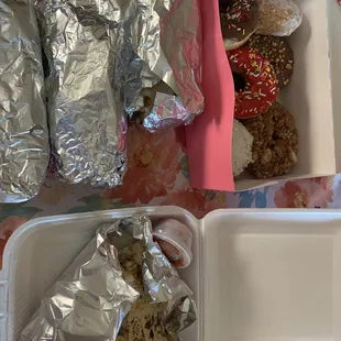 a tray of donuts and a container of cookies