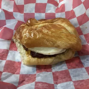a croissant sandwich on a checkered paper