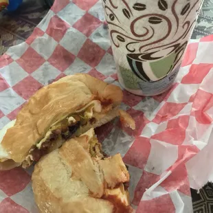 a half eaten sandwich and a cup of coffee