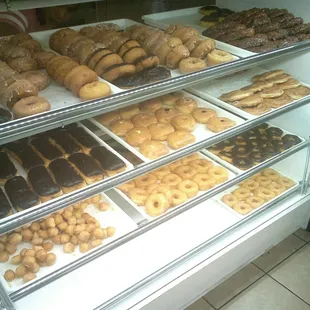a variety of donuts in a display case