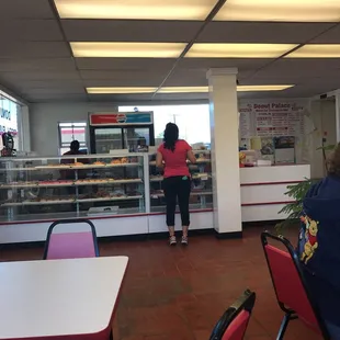 a woman standing in front of a bakery counter