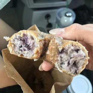 a hand holding a half eaten donut