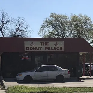 a donut palace with cars parked in front of it