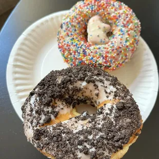 two donuts with sprinkles on a paper plate