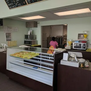 a woman behind the counter of a donut shop