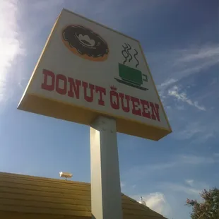 a donut queen sign in front of a donut shop