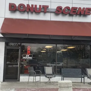 a donut shopfront with chairs outside