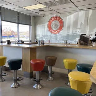 a row of colorful stools in front of a counter