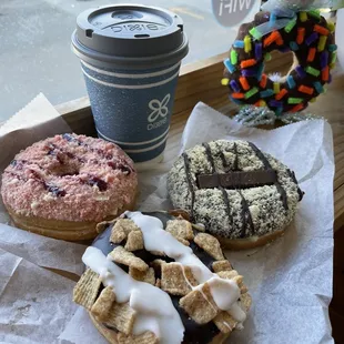 three different types of donuts and a cup of coffee