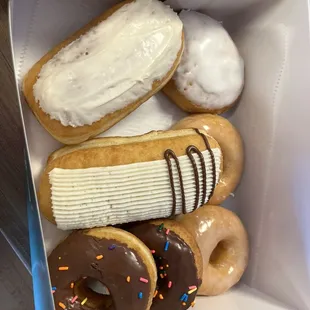 Maple donut, lemon donut, almond vanilla butter cream, chocolate frosted raised donut, chocolate frosted cake donut, and raised donut.
