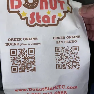 a person holding a bag of donuts