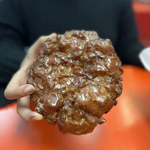 a person holding a chocolate donut