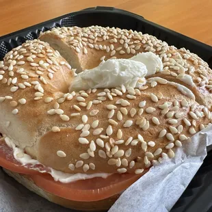 Sesame bagel with cream cheese tomato and onion