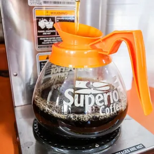 a coffee maker pouring coffee into a cup
