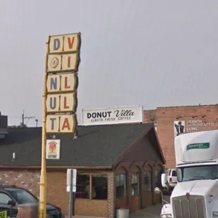 a truck parked in front of a donut palace