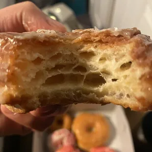 a hand holding a half eaten donut