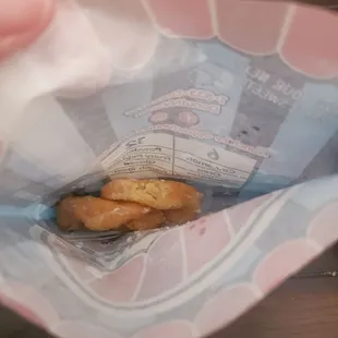 a hand holding a bag of donuts