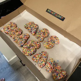 a box of donuts with sprinkles