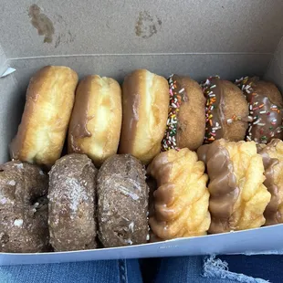 A dozen doughnuts! 3 chocolates glazed, 3 chocolate, 3 chocolate frosting with sprinkles, and 3 crinkle chocolate frosting doughnuts!