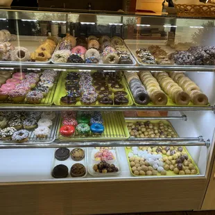 a variety of donuts in a display case