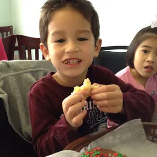 two young children eating donuts