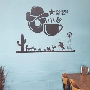 a blue wall with a cowboy hat and a cup of coffee