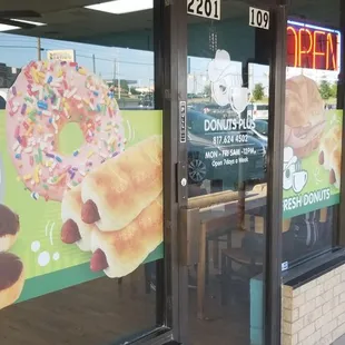 a donut shopfront with a sign in the window