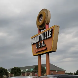a donutville sign and cars in a parking lot