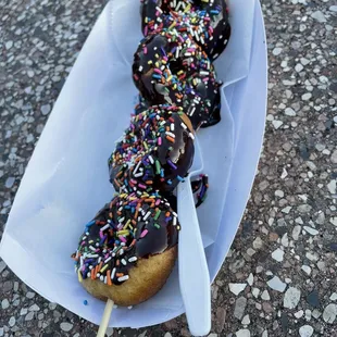 Large donutz on a stick. Chocolate frosting and sprinkles