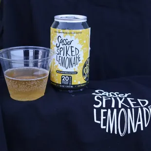 a glass of lemonade next to a can of beer