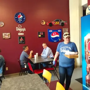 a woman carrying a box of pizza