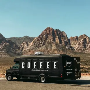 a coffee truck parked in front of a mountain
