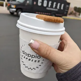 a hand holding a coffee cup