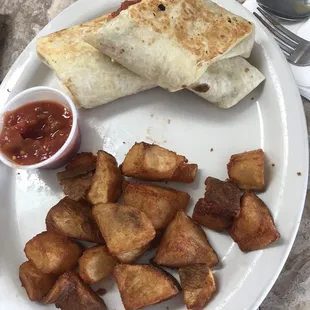 a plate of food with a burrito and potatoes