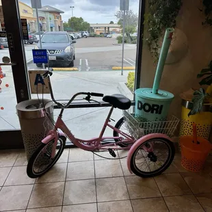  pink bicycle parked in front of a store