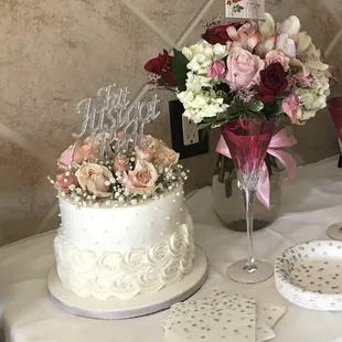 a table with a cake and flowers