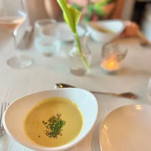 a woman sitting at a table with a bowl of soup