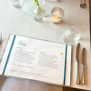 a table setting with a menu and utensils