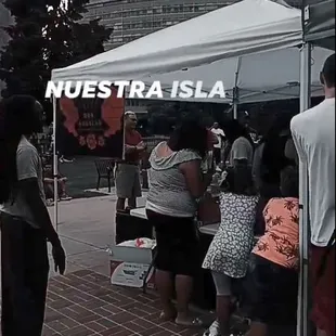 a group of people standing under a tent