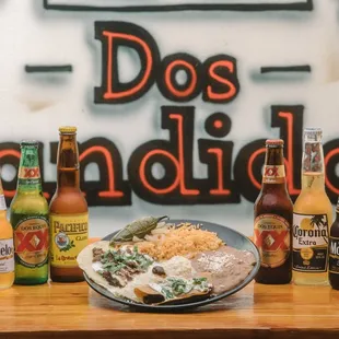 a plate of food and bottles of beer