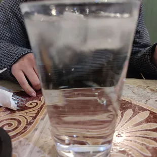 a woman sitting at a table with a glass of water